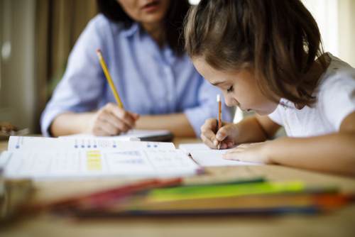 Mother helping daughter with homework Mother helping daughter with homework