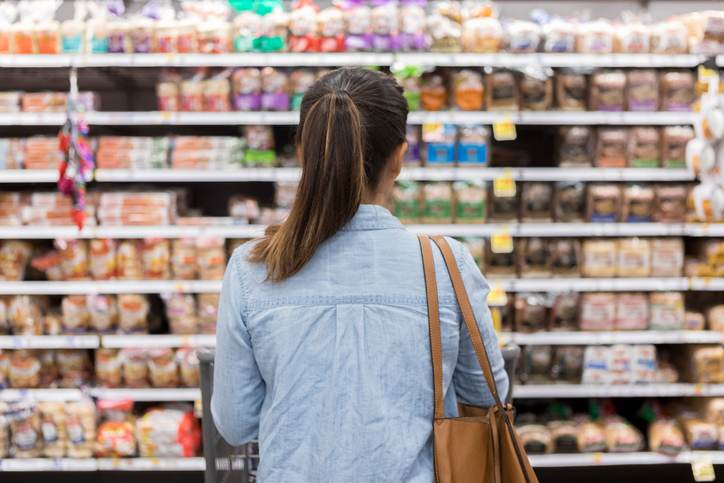 Unrecognizable woman marvels at grocery bread selection Unrecognizable woman marvels at grocery bread selection
