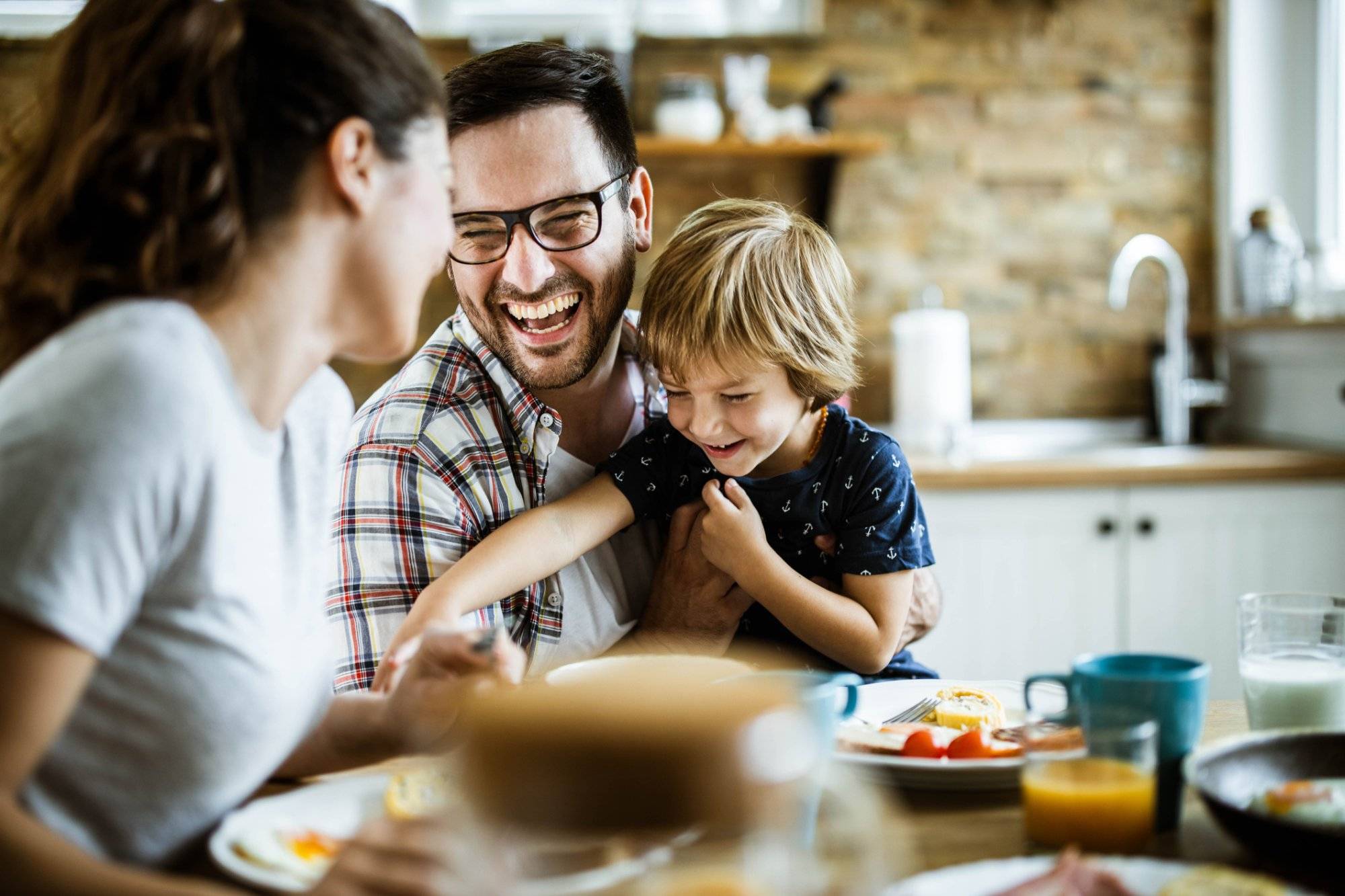 Young cheerful family having fun at dining table. Young cheerful family having fun at dining table.