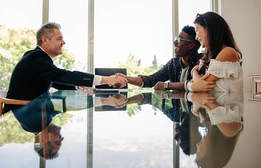 Estate agent congratulating couple after a property deal Estate agent congratulating couple after a property deal