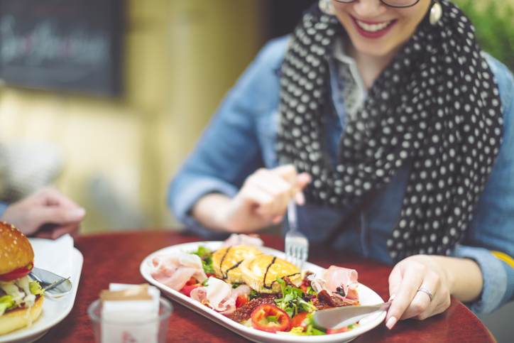 Young woman eating goat cheese salad