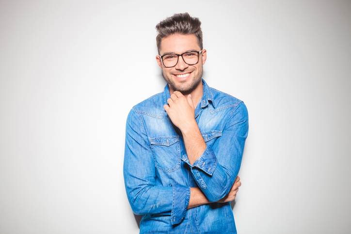 young man smiling and touching his chin