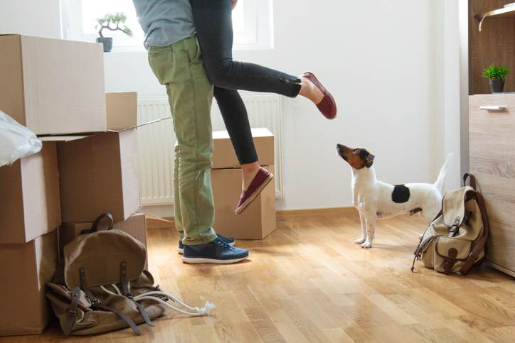 Happy man lifting woman in new house